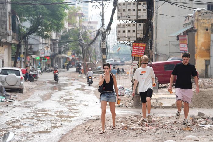 Người dân đi bộ qua khu vực vỉa hè trước những ngôi nhà đã bàn giao mặt bằng cho cơ quan chức năng.Ảnh: Ngọc Tú