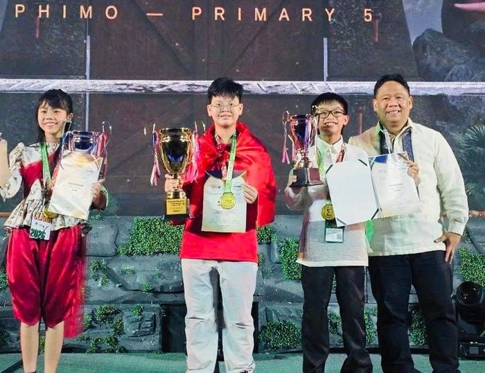 Đại diện Ban Tổ chức trao thưởng cho các học sinh; trong đó em Hoàng Khôi William (giữa) giành Huy chương vàng và danh hiệu Champion. Ảnh: CVL