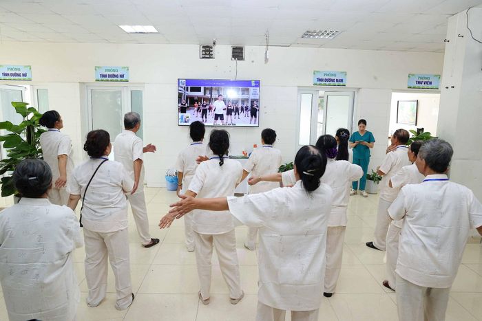 Nhân viên y tế hướng dẫn người cao tuổi tập thể dục. Ảnh: Thanh Hà