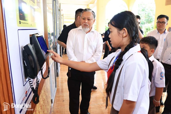 Học sinh thao tác gọi điện thoại về nhà từ Trường tiểu học Hòa Bình bằng thiết bị của MobiFone tài trợ. Ảnh: Công Nghĩa