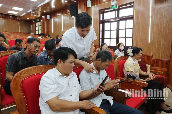 Nhân viên kỹ thuật của Viettel Ninh Bình hướng dẫn cài đặt và đăng nhập ứng dụng trên điện thoại thông minh. Ảnh: Mạnh Hùng