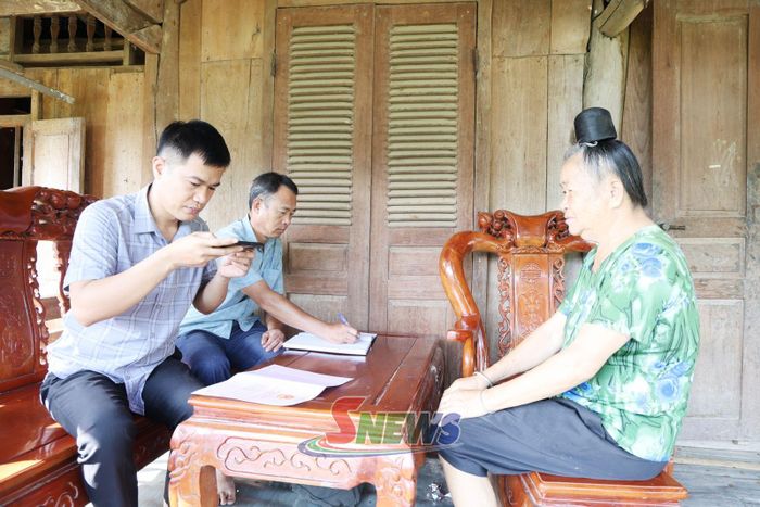 Cán bộ xã Nậm Lầu cập nhật dữ liệu đất đai cho công dân tại nhà.