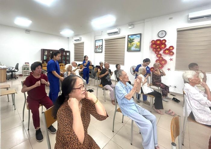 Với sự hướng dẫn của các nhân viên y tế, buổi sáng của các cụ bắt đầu bằng bài tập thể dục vận động nhẹ nhàng. Ảnh: B.Duy