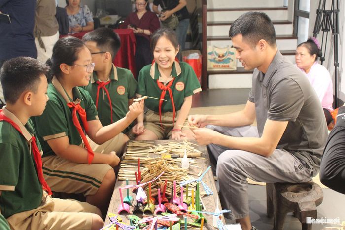 Học sinh thích thú với trải nghiệm nghề làm chuồn chuồn tre Thạch Xá. Ảnh: Vi Giáng