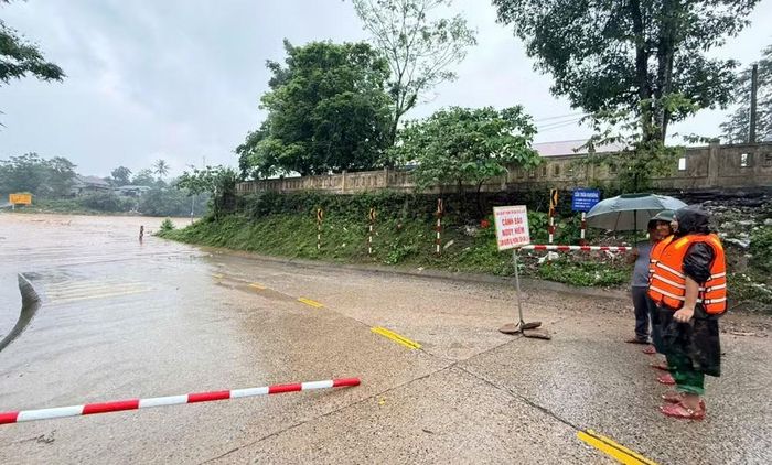 Lực lượng chức năng lập chốt ngăn người dân qua lại khu vực bị ngập do mưa lớn. (Ảnh: H.M)