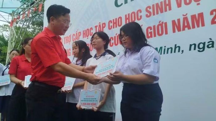 Phó Chủ tịch Trung ương Hội Chữ thập đỏ Việt Nam Nguyễn Sỹ Trường trao trợ cấp học tập cho học sinh vượt khó, hiếu học tại chương trình. (Ảnh: Trịnh Bình)