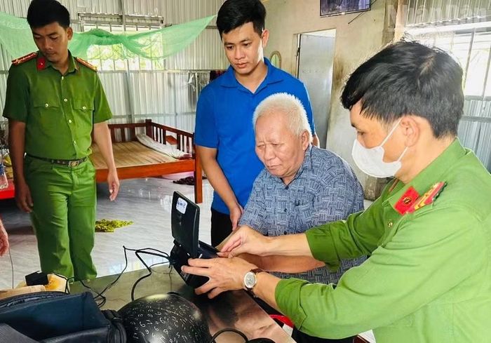 Lực lượng Công an và cán bộ, nhân viên Ủy ban nhân dân xã Vĩnh Hậu đến tận các hộ già yếu, hoàn cảnh khó khăn để giúp người dân làm các thủ tục hành chính. (Ảnh: CTV)