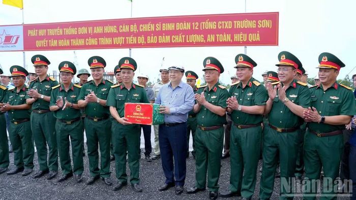Phó Thủ tướng Thường trực Chính phủ Phạm Gia Túc (đứng giữa) tặng quà động viên lực lượng thi công tuyến cao tốc Cà Mau-Đất Mũi. (Ảnh: HỮU TÙNG)
