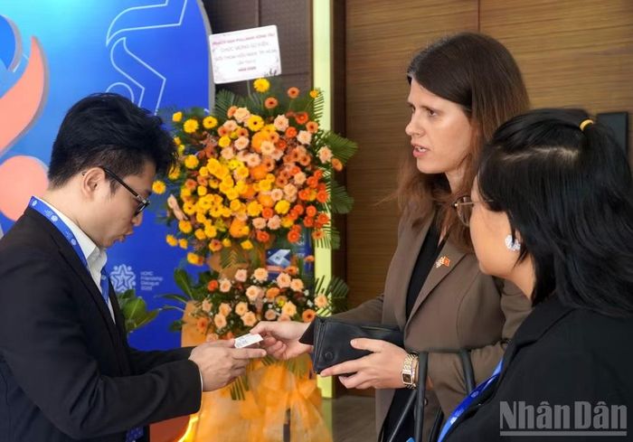 Bà Alexandra Smith, Tổng Lãnh sự Anh tại Thành phố Hồ Chí Minh trao danh thiếp cho một doanh nhân tại Đối thoại Hữu nghị Thành phố Hồ Chí Minh lần thứ 3 năm 2026. (Ảnh: Lê Đình Thìn)