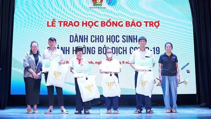 Đại diện Ban tổ chức trao học bổng bảo trợ dành cho các em học sinh bị ảnh hưởng đại dịch Covid-19. (Ảnh: CTV)