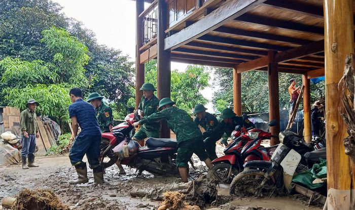 Cán bộ, chiến sĩ Bộ đội Biên phòng tỉnh Nghệ An giúp nhân dân di dời tài sản khỏi khu vực ngập lụt. 