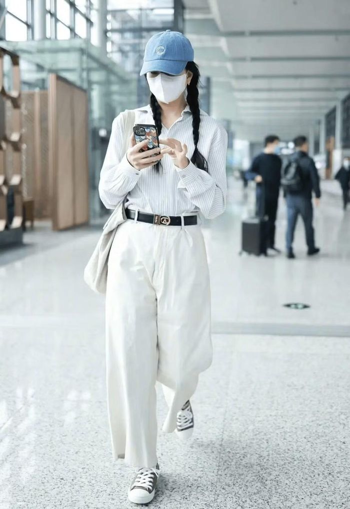 Áo kẻ sọc là lựa chọn rất được ưa chuộng cho mùa Xuân và mùa Thu. Chiếc áo trong hình sở hữu tông màu trầm, mang lại vẻ tinh tế thay vì quá nổi bật hay lòe loẹt. Có hai cách để tạo hiệu ứng giúp đôi chân trông dài hơn, một là sơ vin vạt áo vào trong cạp quần, hai là chọn áo dáng lửng (crop-top). Cả hai đều giúp tôn lên vóc dáng người mặc. Chiếc mũ lưỡi trai có tông màu chủ đạo là xanh dương với họa tiết màu trắng ở mặt trước. Quần có màu trắng trơn, được cắt may với độ dài vừa chạm mắt cá chân và phần gấu quần được xử lý gọn gàng, tránh tình trạng bị nhăn hay đùn vải. Giày sneaker vải canvas rất được các "tín đồ" thời trang ưa chuộng. Thiết kế đế bằng giúp bạn không bị mỏi chân khi mang. Tuy nhiên, do có dây buộc nên bạn cần cẩn thận một chút khi sử dụng, nếu dây giày không được buộc kỹ, bạn có thể bị vấp ngã khi đang đi lại.