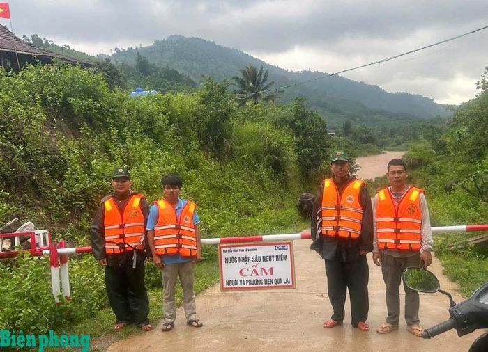 Cán bộ, chiến sĩ Đồn Biên phòng Ba Nang phối hợp với lực lượng địa phương túc trực tại điểm ngập sâu, không cho người dân qua lại để đảm bảo an toàn. Ảnh: Đơn vị cung cấp