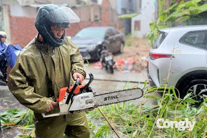 Cán bộ, chiến sĩ sử dụng cưa máy xử lý cây xanh, vật cản do mưa lớn gây ra.