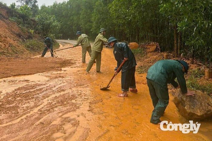 Lực lượng vũ trang xã khẩn trương khơi thông đất đá, xử lý điểm sạt lở trên tuyến đường giao thông.