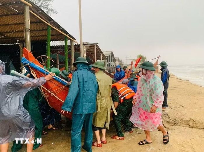 Ủy ban Nhân dân xã Mỹ Thủy huy động các lực lượng chức năng và người dân hỗ trợ đưa tài sản ra khỏi khu vực nguy hiểm. (Ảnh: TTXVN phát)