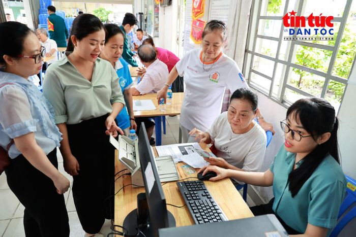 Cán bộ phường hướng dẫn người dân sử dụng tài khoản VNeID và thực hiện các bước nộp hồ sơ trực tuyến.