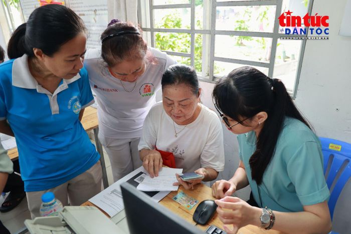 Bà Ngô Thị Hoa (thứ 2 từ phải sang), Khu phố 13 tìm hiểu cách thực hiện thủ tục hành chính trực tuyến tại điểm hỗ trợ.