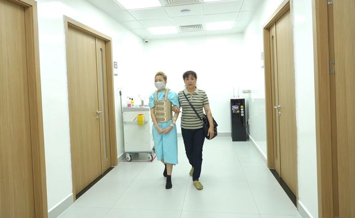 Sau phẫu thuật, bệnh nhân ngồi dậy và tập đi nhẹ nhàng.