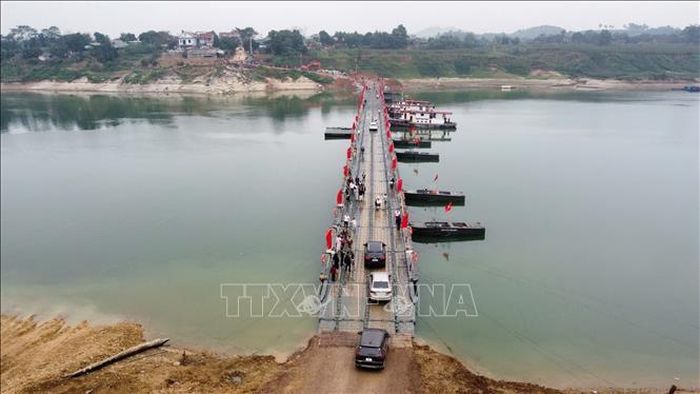 Người và phương tiện lưu thông qua cầu phao sông Lô. Ảnh tư liệu: Nguyễn Văn Cảnh/TTXVN