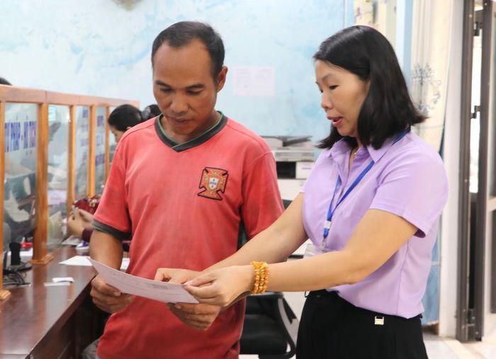 Cán bộ tại Trung tâm Phục vụ hành chính công xã Sơn Mai hướng dẫn người dân kiểm tra thông tin khi bàn giao sổ đỏ.
