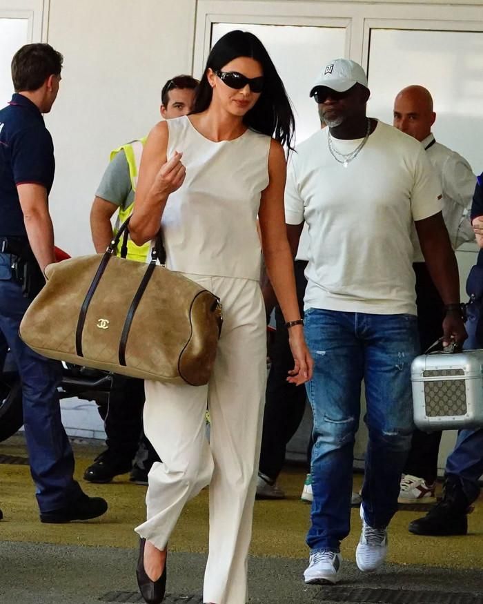 Người mẫu Kendall Jenner diện set đồ màu kem của Prada, ra mắt từ năm 1998, kết hợp giày bệt The Row, kính râm oversized của Side Eye NYC và túi Chanel cỡ lớn. 