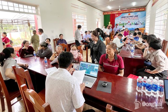 Cán bộ, công chức xã Phú Lâm hướng dẫn, hỗ trợ người dân ấp Phú Sơn thực hiện các thủ tục hành chính trong ngày thứ 7, 12-9-2026. Ảnh: ĐPCC