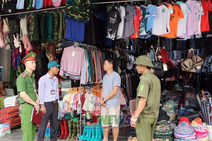 Các lực lượng chức năng tuyên truyền hộ kinh doanh chấp hành các quy định về hành lang an toàn giao thông.