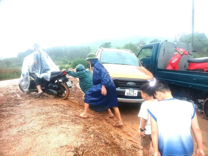 Chính quyền xã Quế Phước hỗ trợ người dân lưu thông qua khu vực khó khăn.