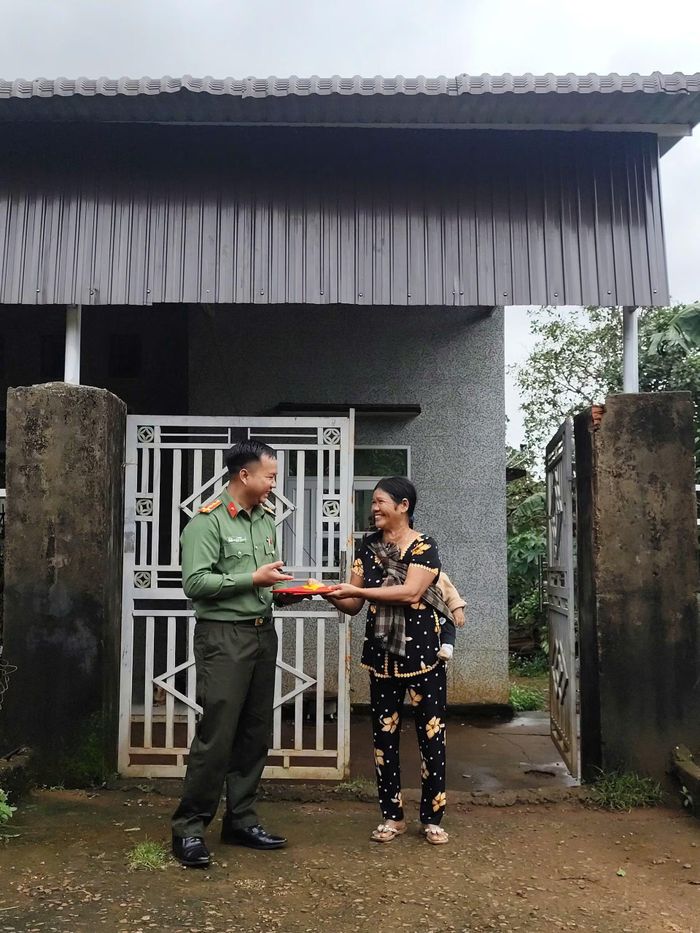 Bà Rơ Lan Pối nhận cờ Tổ quốc do lực lượng Công an xã Ia Dơk trao tặng.