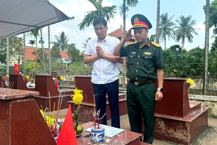 Trung tá Nguyễn Ích Hòa, Chỉ huy trưởng Ban Chỉ huy Quân sự xã Dương Hòa và Trưởng phòng Văn hóa - Xã hội xã Dương Hòa Nguyễn Viết Thanh nghiêm trang thực hiện nghi thức trước các phần mộ liệt sĩ chưa xác định danh tính. Ảnh: Mai Hoa