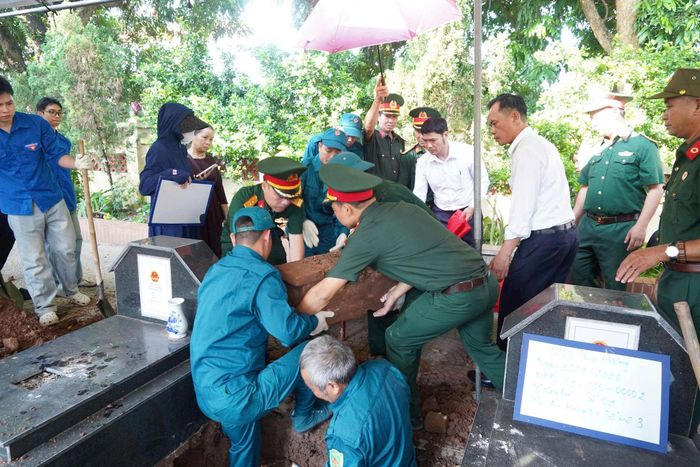 Các lực lượng tiến hành mở phần mộ liệt sĩ theo quy trình chuyên môn. Ảnh: Lan Oanh