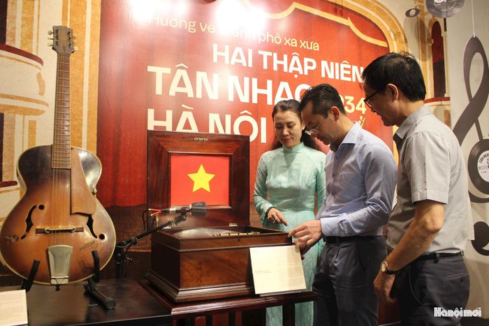 Phó Giám đốc Sở Văn hóa, Thể thao và Du lịch Phạm Xuân Tài (đứng giữa) và các đại biểu tham quan các hiện vật quý Hộp nhạc cơ và đĩa nhạc "Tiến quân ca" - ca khúc do nhạc sĩ Văn Cao sáng tác năm 1944. Ảnh: Mộc Miên