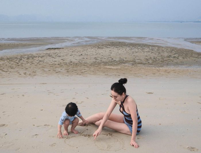 Mai Ngọc dạy con trai viết chữ trên cát hay đi chân trần trên cát. "Cháu vừa sợ vừa thích khi lần đầu đặt chân xuống biển", MC Mai Ngọc mô tả.