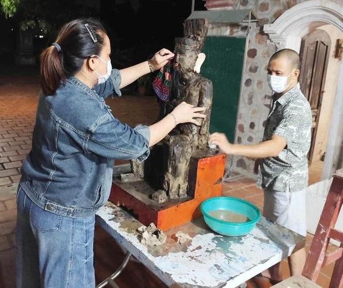 Người dân phục chế pho tượng sau khi đưa từ bãi biển về. Ảnh: Tâm Phạm
