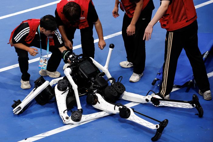  Các thành viên đội bảo trì kiểm tra robot hình người Tiangong Ultra sau khi chúng bị ngã trong cuộc đua chung kết. Ảnh: Reuters. 