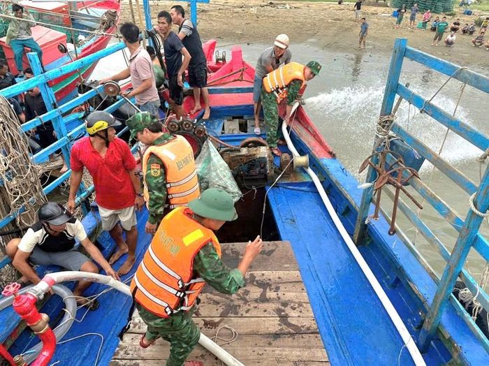 Cán bộ, chiến sĩ Đồn Biên phòng Hải Hòa cùng người dân khẩn trương trục vớt tàu cá bị chìm. Ảnh: Đồn Biên phòng Hải Hòa