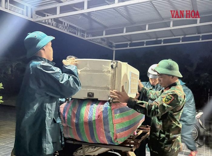 Lực lượng chức năng hỗ trợ người dân di dời tài sản lên điểm cao để tránh lũ