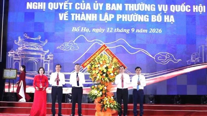 Phó Giáo sư, Tiến sĩ Dương Trung Ý, Ủy viên Trung ương Đảng, Tổng Biên tập Tạp chí Cộng sản (thứ 2, phải sang) tặng hoa chúc mừng Đảng bộ, chính quyền và nhân dân phường Bố Hạ. (Ảnh: DL)