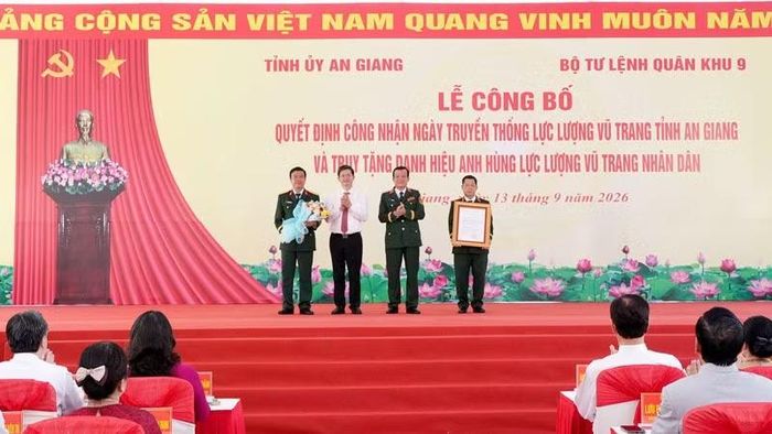 Trung Tướng Hồ Văn Thái (thứ hai, từ phải qua), Bí thư Đảng ủy, Chính ủy Quân khu 9 và đồng chí Lê Quang Tùng, Ủy viên Trung ương Đảng, Bí thư Tỉnh ủy tỉnh An Giang trao Quyết định công nhận Ngày truyền thống lực lượng vũ trang tỉnh An Giang và tặng hoa chúc mừng. (Ảnh: LÊ HUY HẢI)