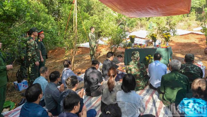 Các đại biểu cùng người dân và lực lượng chức năng làm lễ trước khi tiến hành cất bốc 28 hài cốt liệt sĩ. (Ảnh: CÔNG HẢI)