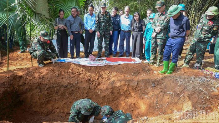 Lực lượng chức năng tiến hành cất bốc hài cốt liệt sĩ. (Ảnh: CÔNG HẢI)