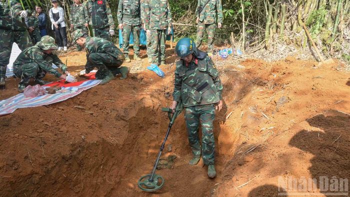 Trong quá trình cất bốc, lực lượng chức năng phát hiện có vật liệu nổ, ngay lập tức lực lượng công binh đã có mặt tiến hành rà phá và xử lý, bảo đảm tuyệt đối an toàn. (Ảnh: CÔNG HẢI)