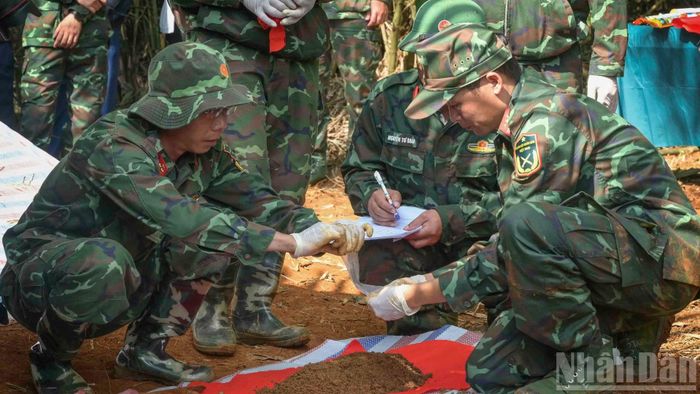 Dù thời tiết nắng nóng, phải làm việc liên tục, các lực lượng vẫn miệt mài thực hiện nhiệm vụ, tuân thủ nghiêm quy trình cất bốc, đồng thời tiến hành lấy mẫu sinh phẩm để phục vụ công tác giám định ADN hài cốt liệt sĩ. (Ảnh: CÔNG HẢI)