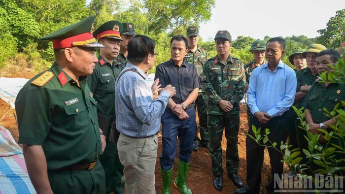 Đồng chí Giàng Quốc Hưng (người mặc áo đen), Phó Chủ tịch Ủy ban nhân dân tỉnh Lào Cai và Thượng tá Lương Hoàng Giang, Chính ủy Bộ Chỉ huy quân sự tỉnh có mặt từ sớm trò chuyện với các cựu chiến binh và chỉ đạo công tác cất bốc hài cốt liệt sĩ. (Ảnh: CÔNG HẢI)