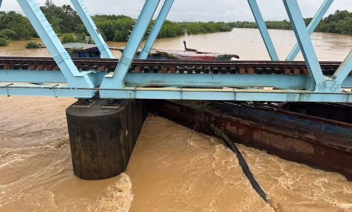 Cụm sà-lan mắc kẹt dưới chân cầu đường sắt Mỹ Chánh. (Ảnh: H.M)