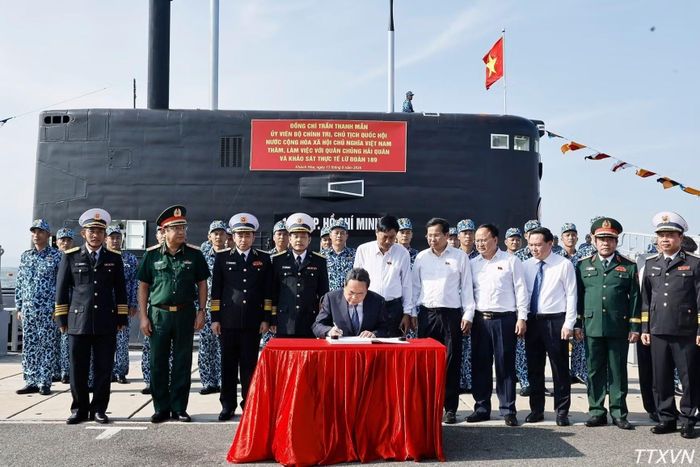 Chủ tịch Quốc hội Trần Thanh Mẫn ghi sổ lưu niệm về truyền thống Lữ đoàn 189. (Ảnh: TTXVN)
