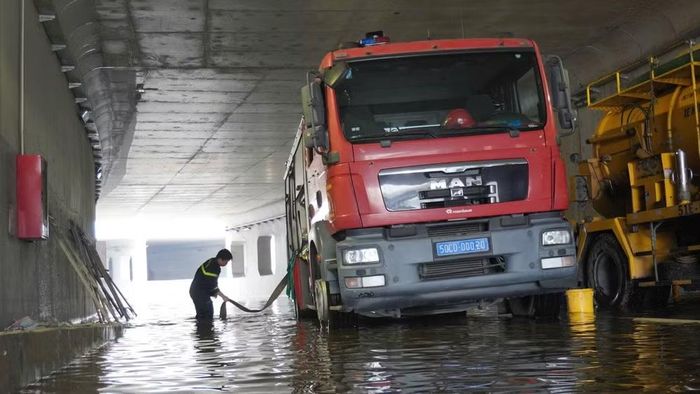 Các đơn vị chức năng huy động xe chuyên dụng, máy bơm hút nước và khơi thông hệ thống thoát nước tại hầm chui An Phú thuộc Dự án thi công nút giao An Phú. (Ảnh: QUÝ HIỀN)