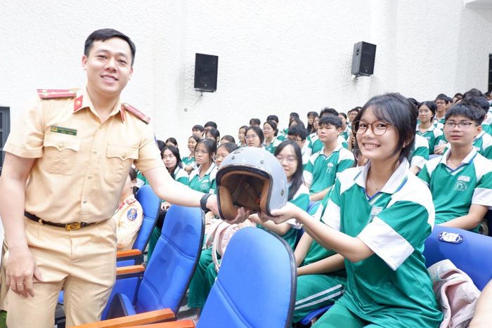 Trao thưởng mũ bảo hiểm cho HS trả lời và giải thích đúng câu hỏi. Ảnh: P.T