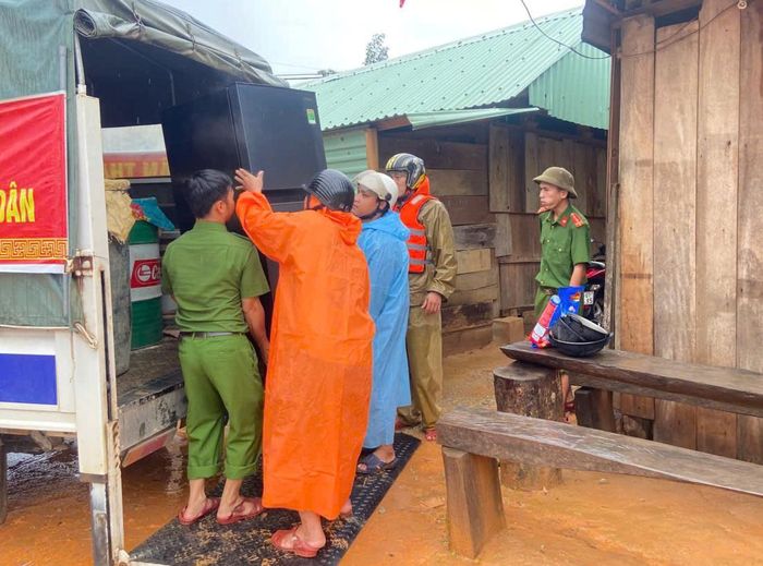 Lực lượng Công an xã Tây Giang phối hợp với các lực lượng hỗ trợ người dân di dời đồ đạc, tài sản đến nơi an toàn.